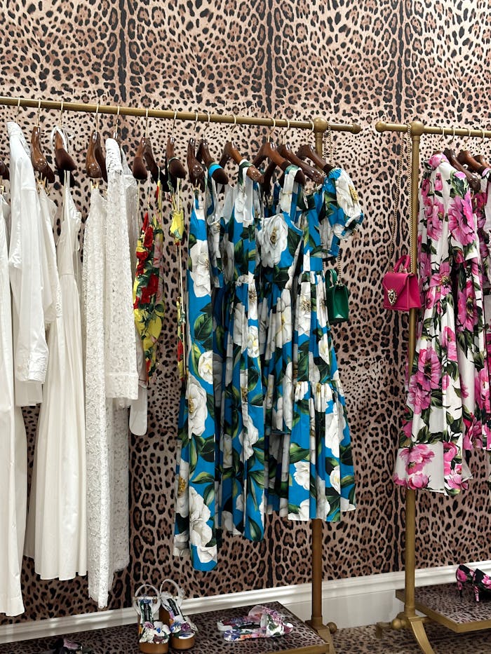 gallery-3 Colorful and elegant dresses displayed on a leopard print backdrop in a stylish boutique.