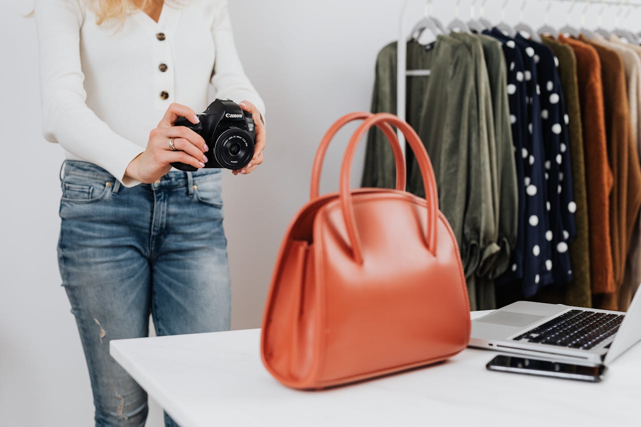 gallery-1 Stylish fashion photo shoot setup with handbag, clothes, and camera.